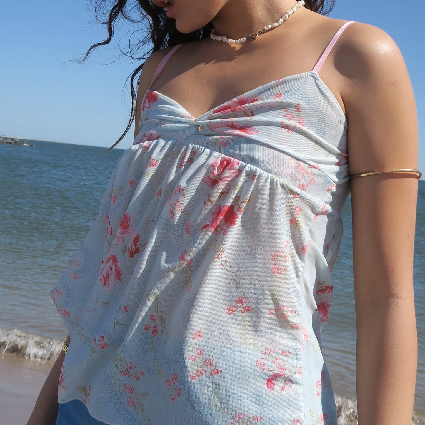 Woman wearing a floral dress by the beach
